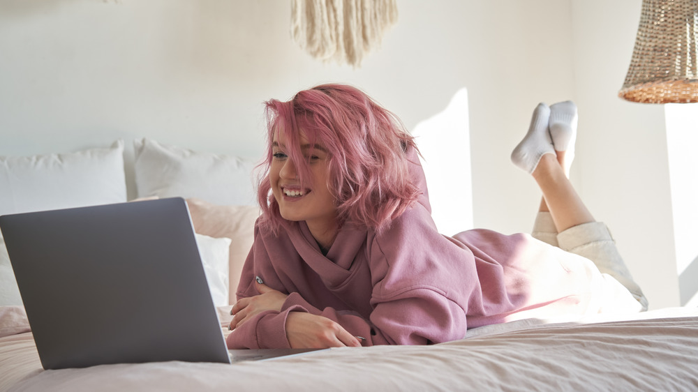 A woman watching TV on her laptop