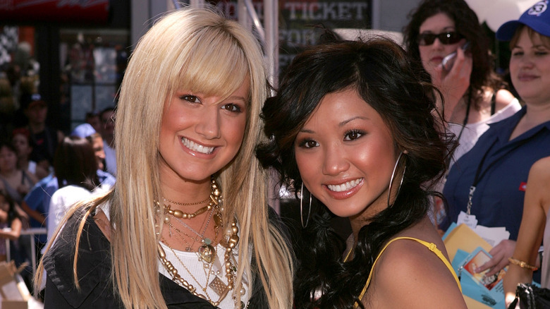 Ashley Tisdale and Brenda Song posing at outdoor event