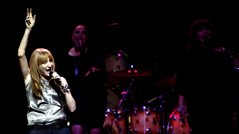 Patti Scialfa singing with her arm in the air