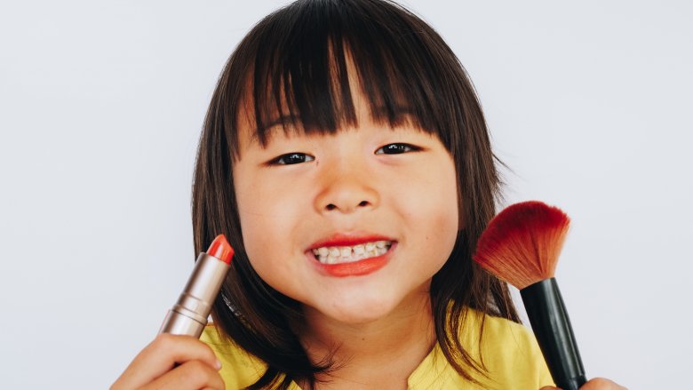 Little girl putting on makeup