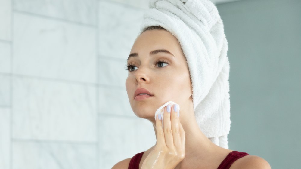 Woman washes her face with clean beauty product