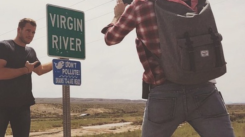 Colton Underwood posing beside Virgin River sign