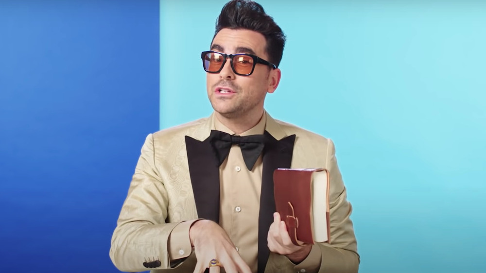 Dan Levy holding a book