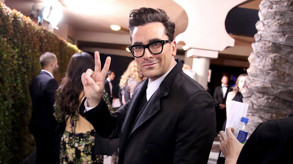 Dan Levy flashing a peace sign