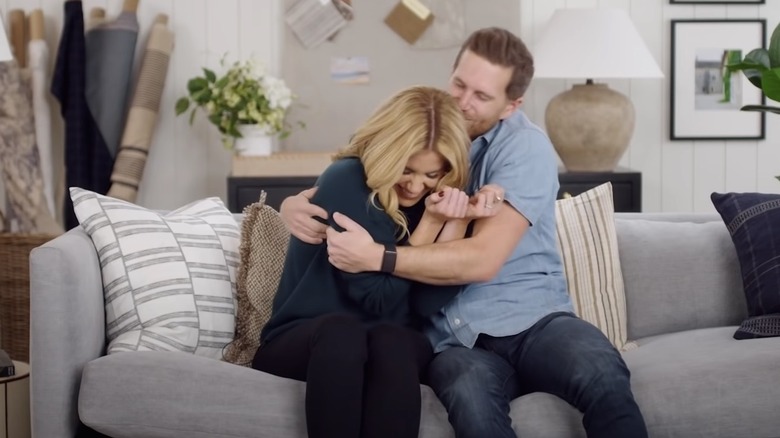 Dream Home Makeover's Shea and Syd McGee on a couch, hugging