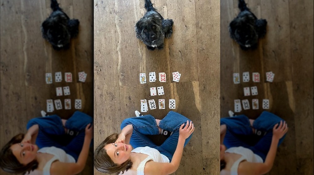 Emma Corrin playing cards with her dog