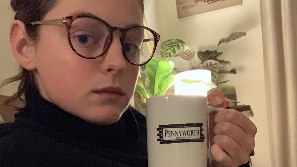 Emma Corrin drinking a mug of tea