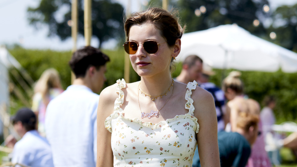 Emma Corrin wearing sunglasses at an outdoor event