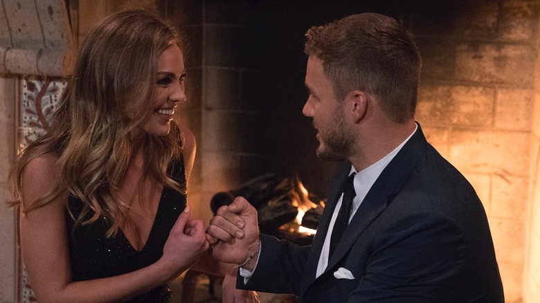 Hannah B. and Colton Underwood by a fireplace