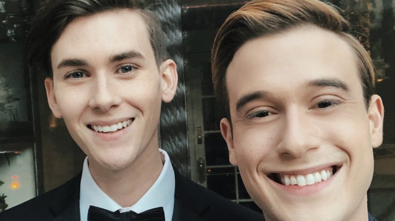 Clint Goodwin and Tyler Henry in black suits posing for a picture together.