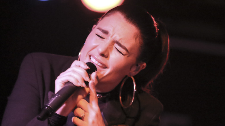 Jessie Ware singing into a microphone