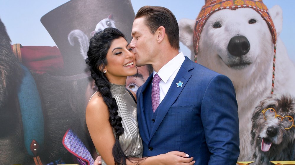 John Cena and wife Shay Shariatzadeh smooching in front of an animal mural