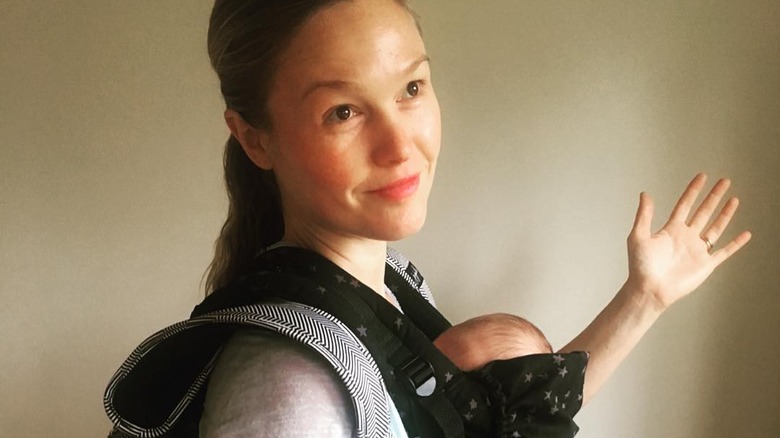 Julia Stiles arm out with baby