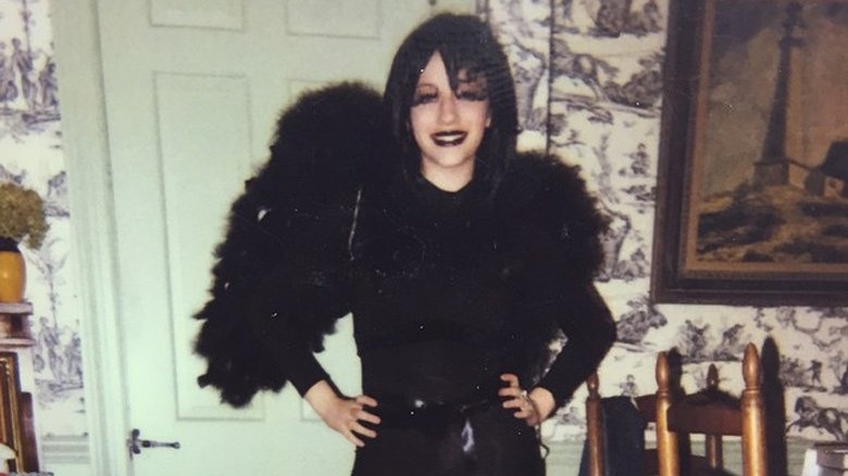 Kat Dennings posing and smiling in goth attire