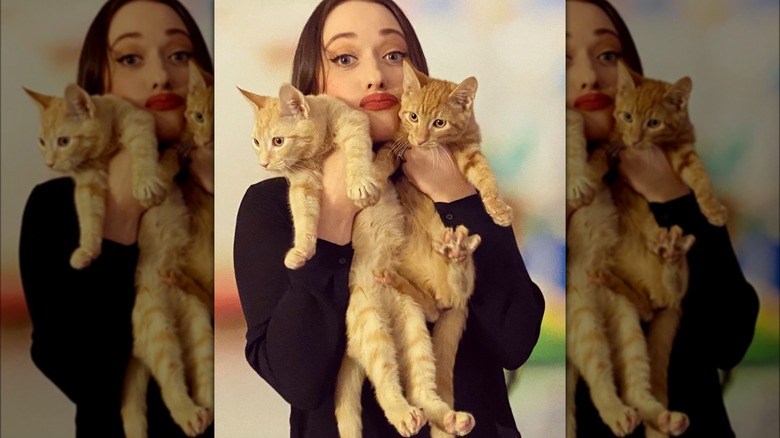 Kat Dennings posing with a pair of cats