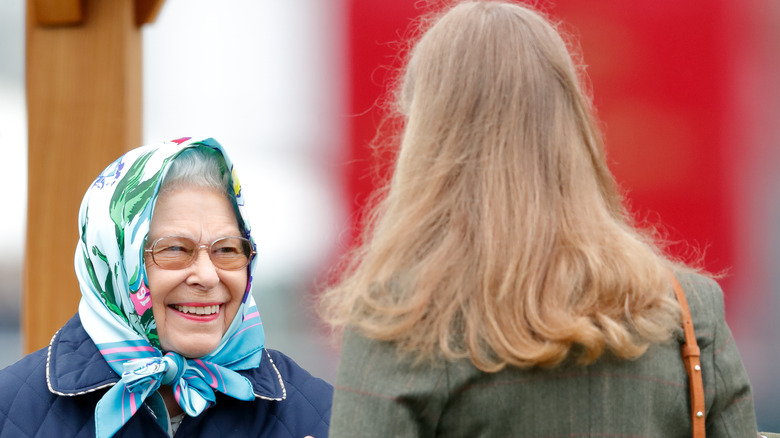 The queen smiling at Lady Louise