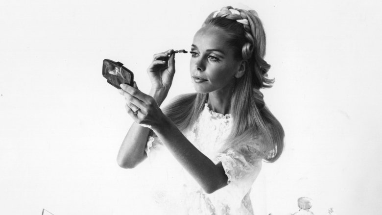 Woman applying mascara, 1960s