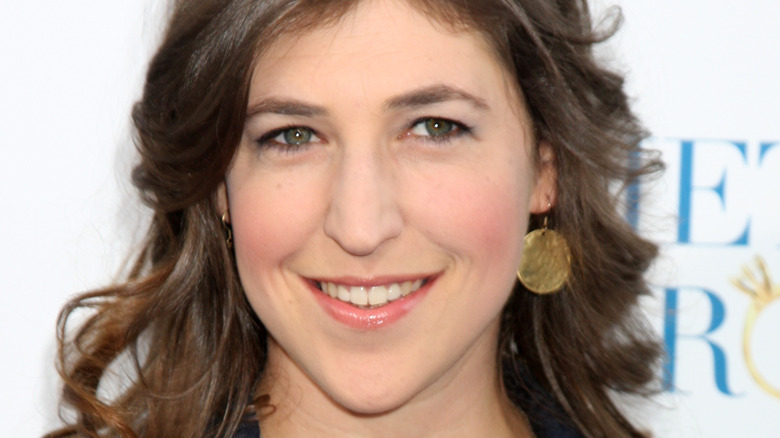 Mayim Bialik wearing earrings, smiling