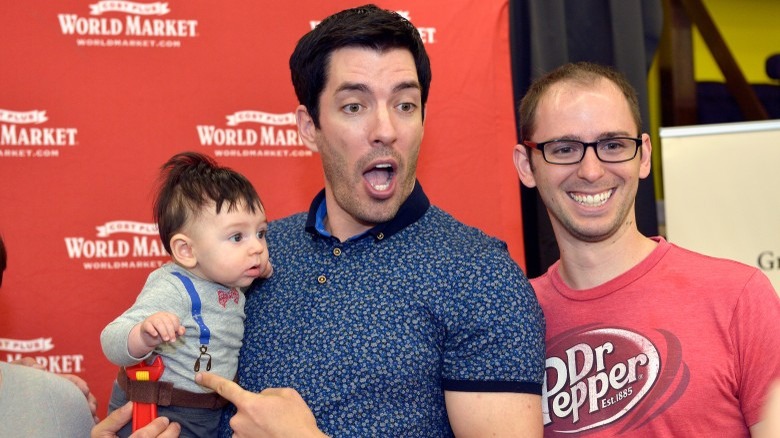 Property Brothers star Drew Scott holding a baby