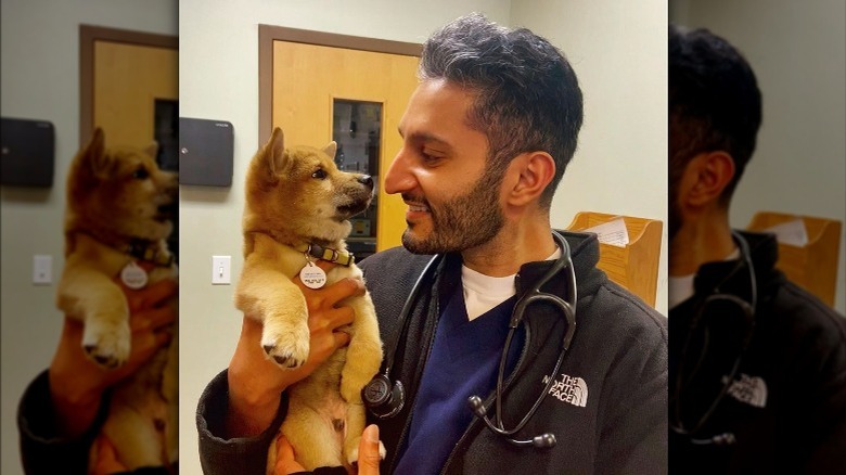 Shake Chatterjee holding a puppy and smiling