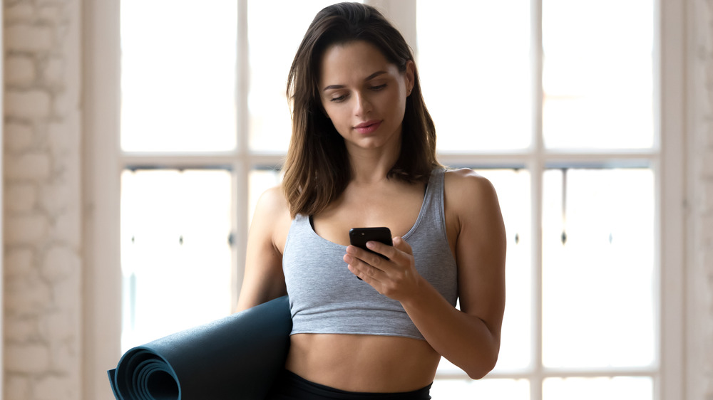 A woman in a sports bra on phone