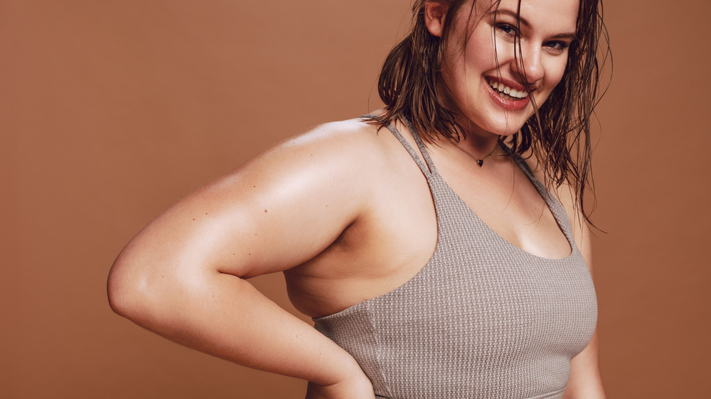 A woman smiling in a sports bra