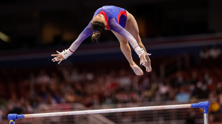 Sunisa Lee flipping above the uneven bars