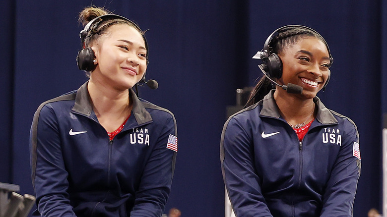 Sunisa Lee and Simone Biles wearing headsets