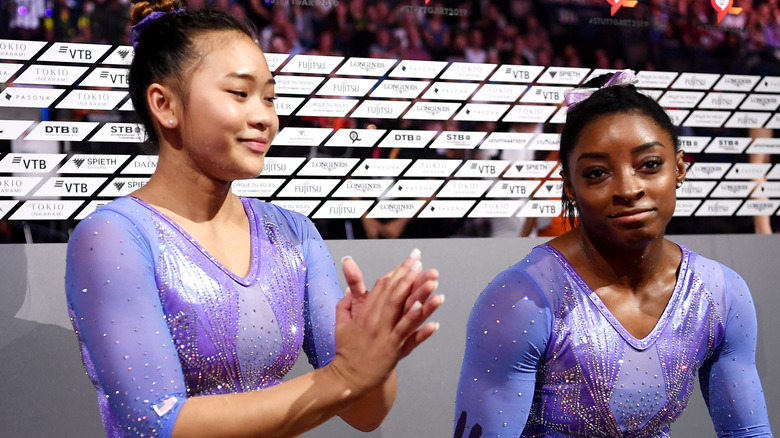 Sunisa Lee with Simone Biles on a bench