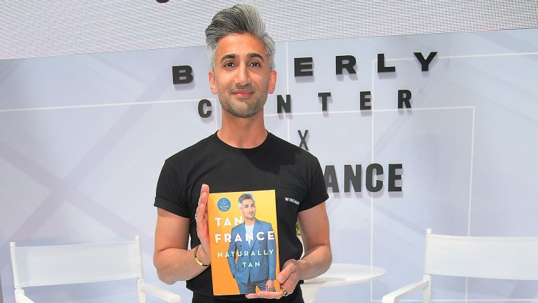 Queer Eye star Tan France with his memoir, Naturally Tan