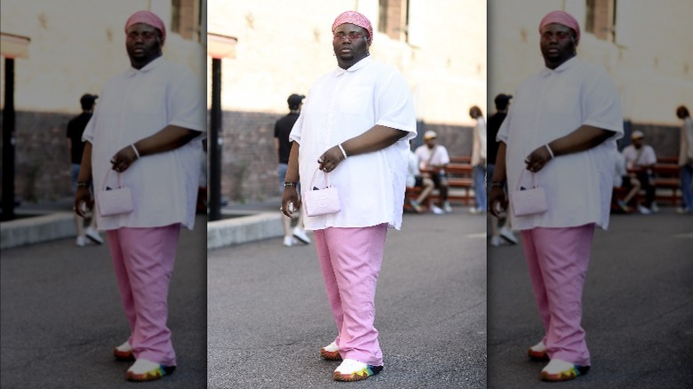 Person in a pink outfit holding a pink mini bag