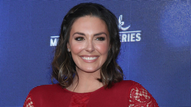 Taylor Cole smiling in red dress