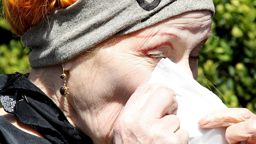 Vivienne Westwood dabbing her eye with a tissue