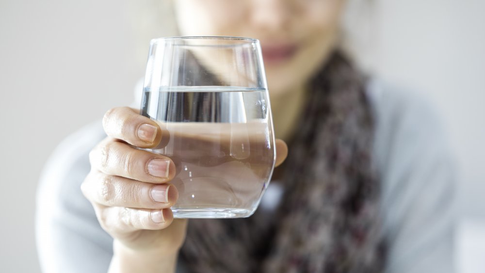 Woman holding glass of water