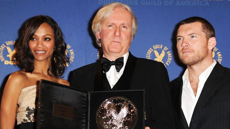 Zoe Saldana, James Cameron, and Sam Worthington posing with the Feature Film Nomination Plaque for 'Avatar'