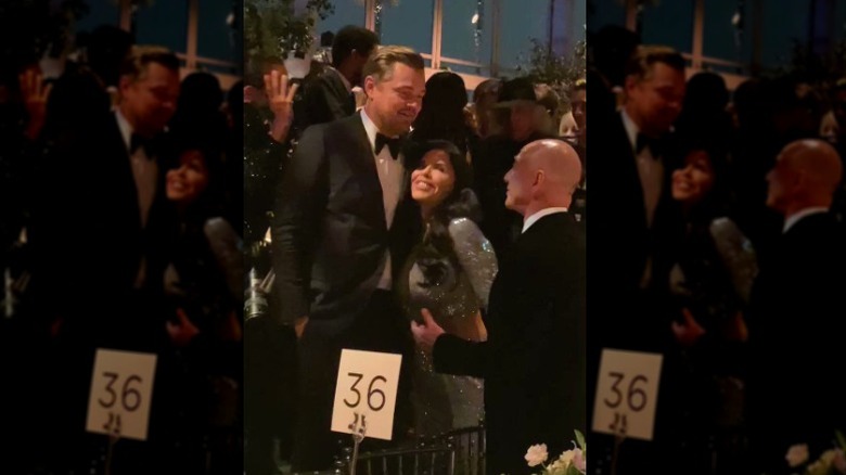 Leonardo DiCaprio embraces Lauren Sanchez as Jeff Bezos looks on