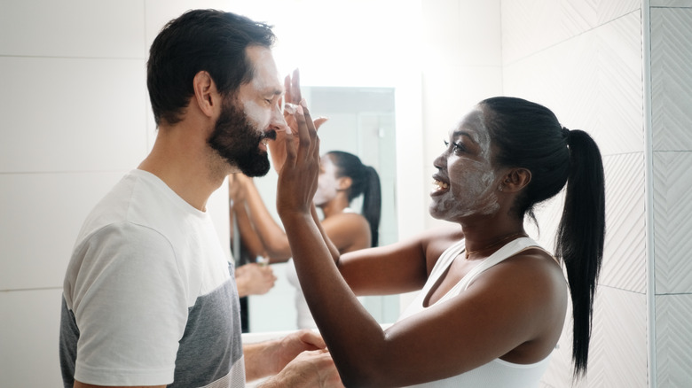 Couple applying facial cream to each other