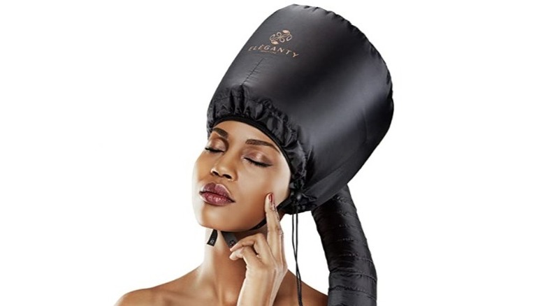 woman using bonnet hair dryer