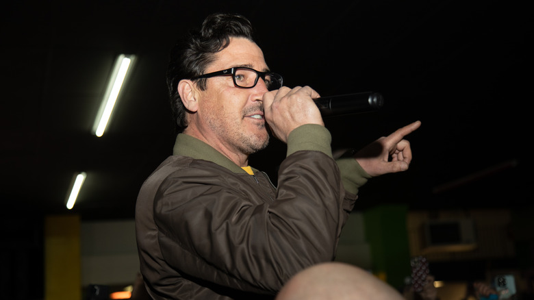 Jonathan Knight pointing while talking into a microphone