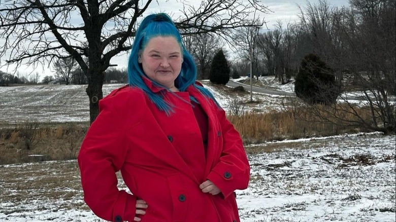 Amy Slaton posing outside in red coat with blue hair