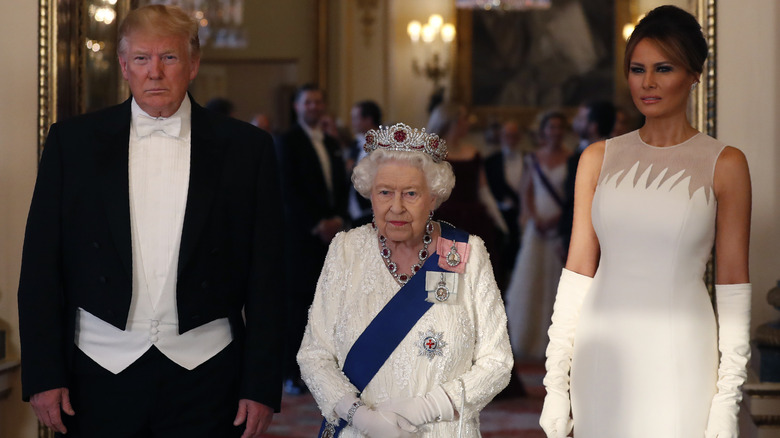 Donald and Melania Trump posing with the queen