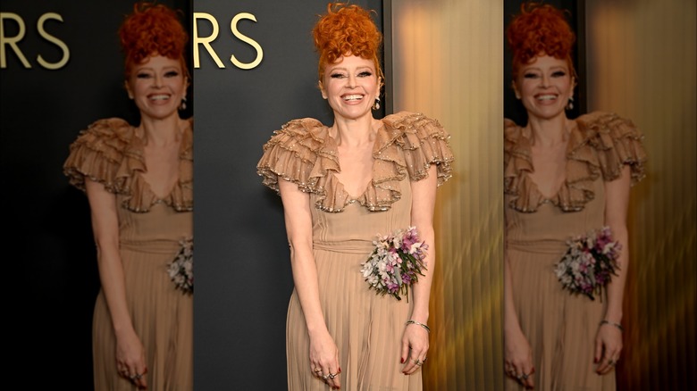 Natasha Lyonne smiling in tan dress