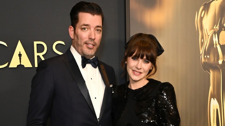 Jonathan Scott smiling with Zooey Deschanel on red carpet