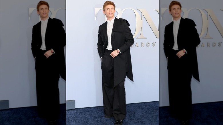 Eddie Redmayne in tux with bow on shoulder