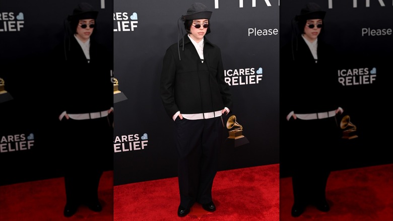 Billie Eilish posing in black ensemble and sailor hat