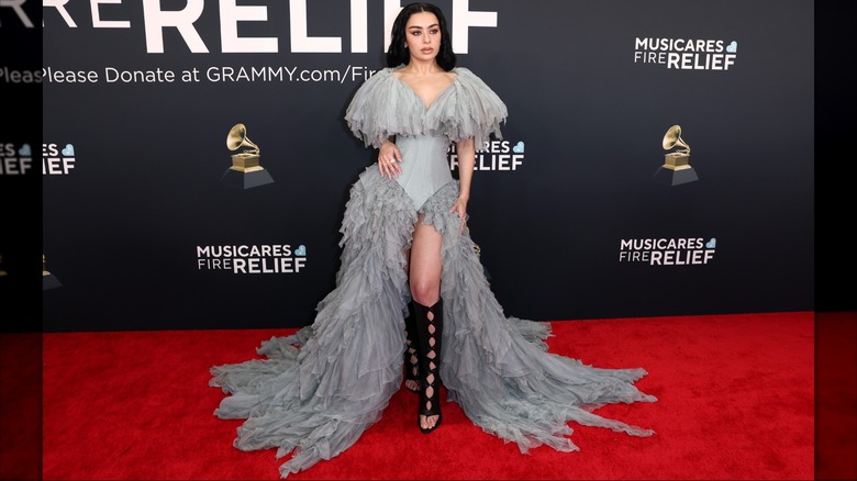 Charli XCX posing in grey ruffled dress