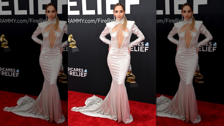 Jesaiah posing on the red carpet in white dress