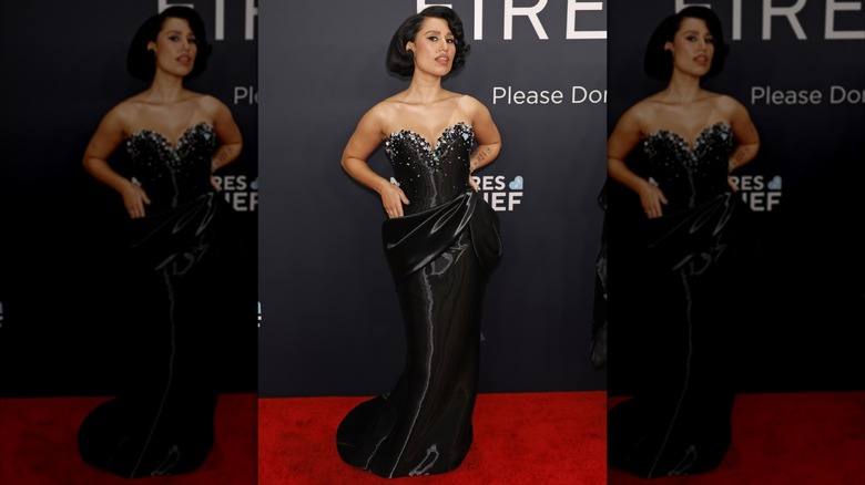 Raye posing on the red carpet in black dress