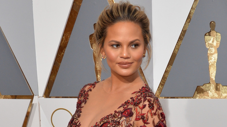 Chrissy Teigen wearing a red floral embellished dress