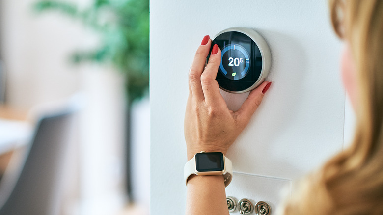 woman holding thermostat